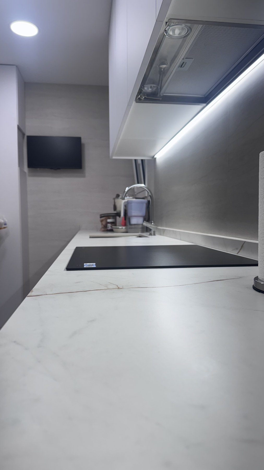 Vista de cocina con encimera clara y muebles de madera