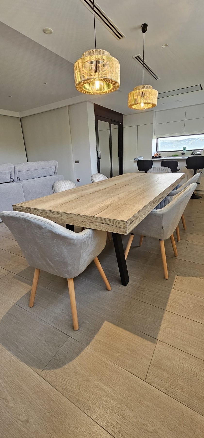 Mesa de comedor a medida en acabado madera con patas negras, instalada en una vivienda
